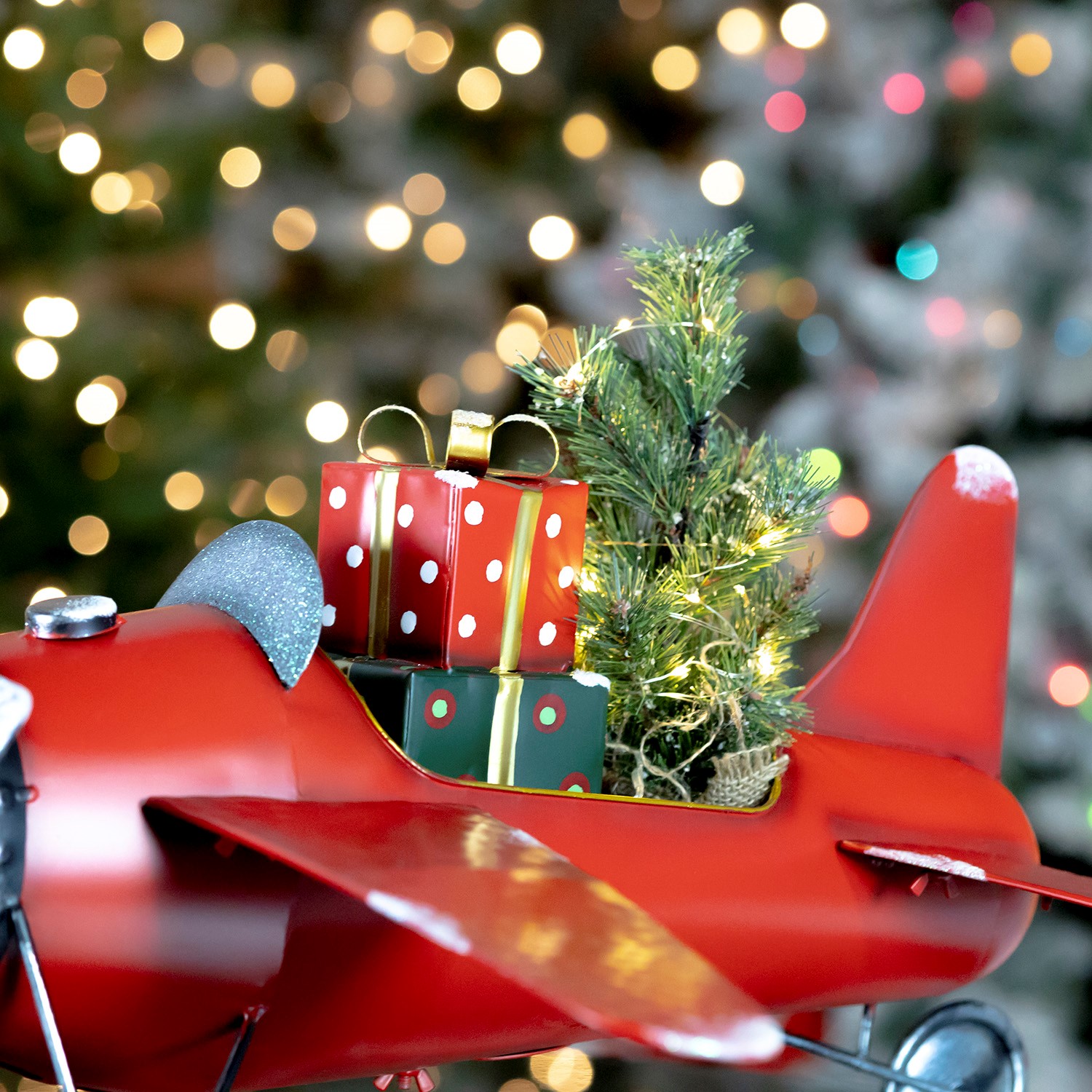 Small Red Airplane with Lighted Christmas Tree and Gifts
